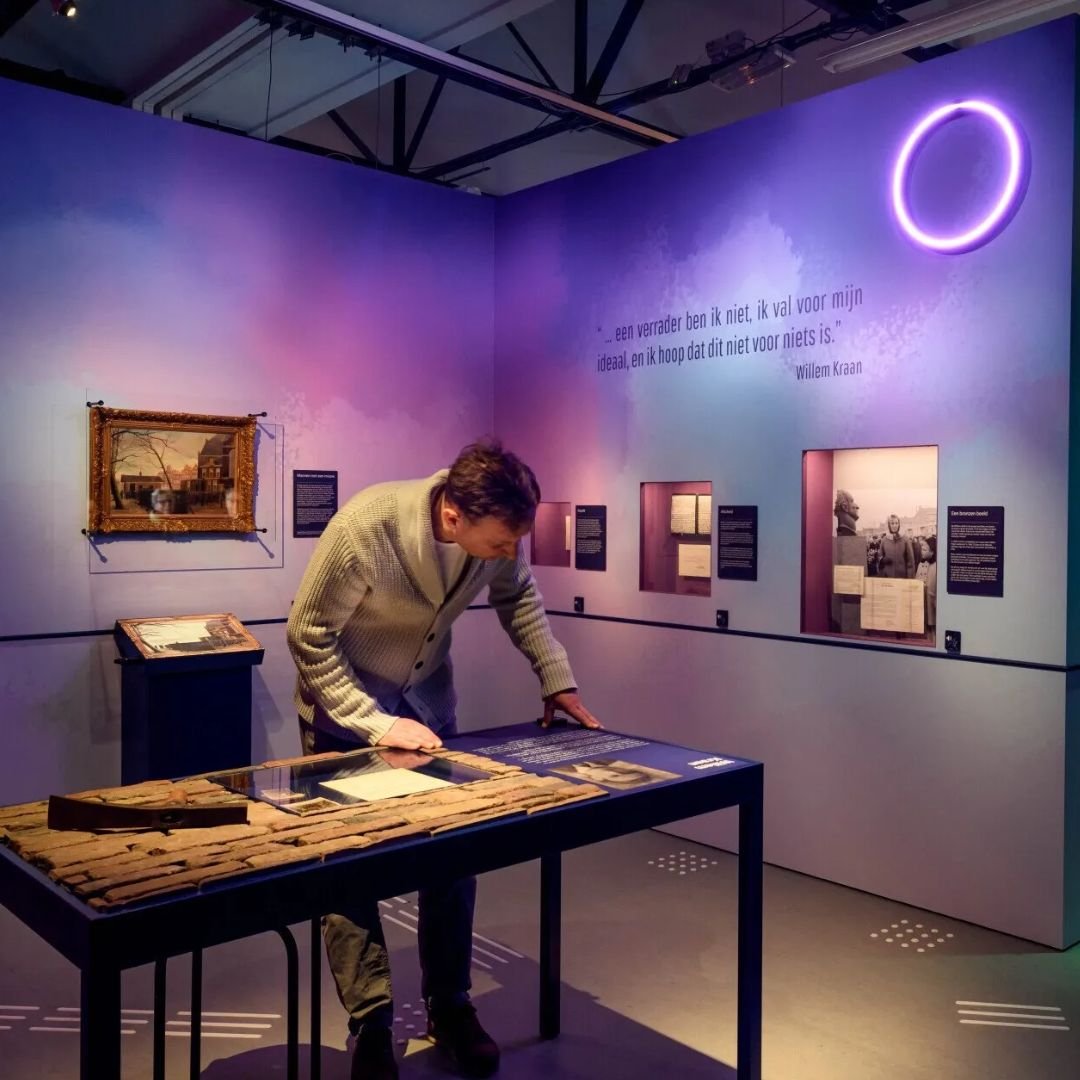 Person looking at a display table in a museum exhibit at the Dutch Resistance museum